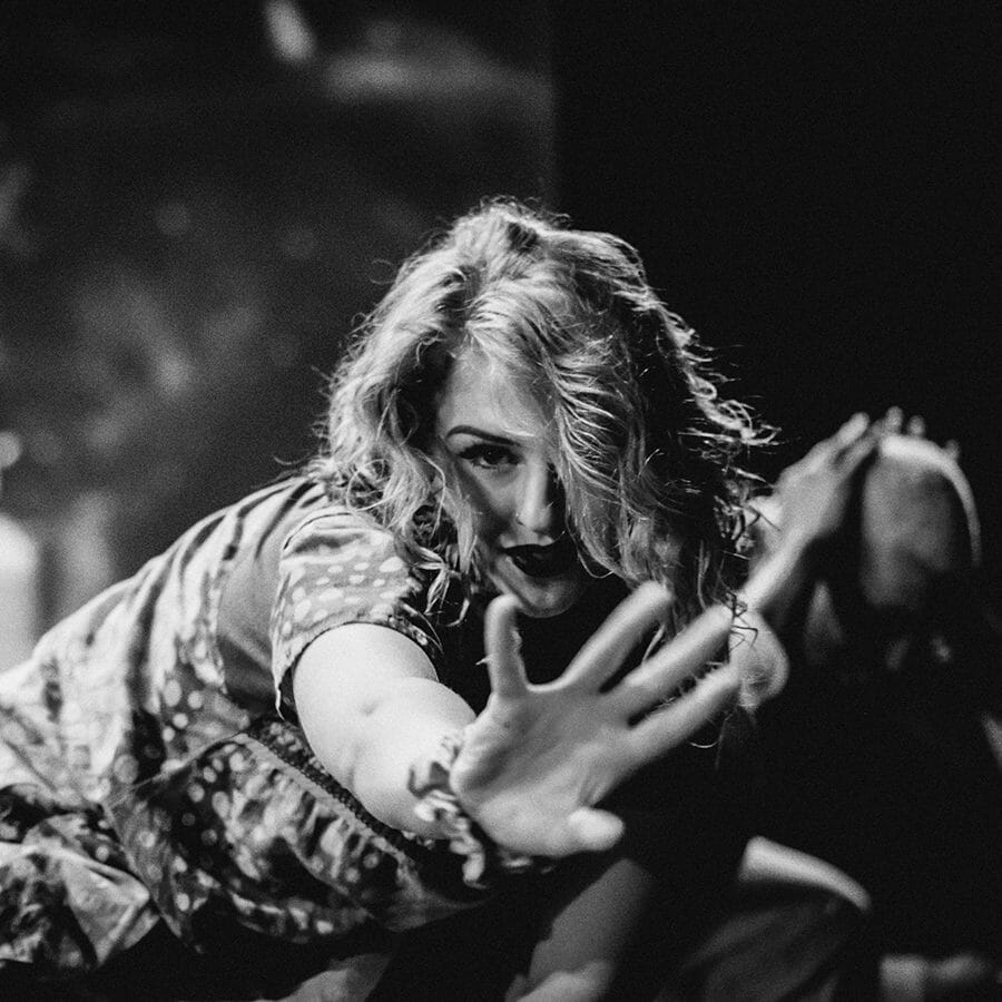 A black and white photo of a woman on stage.