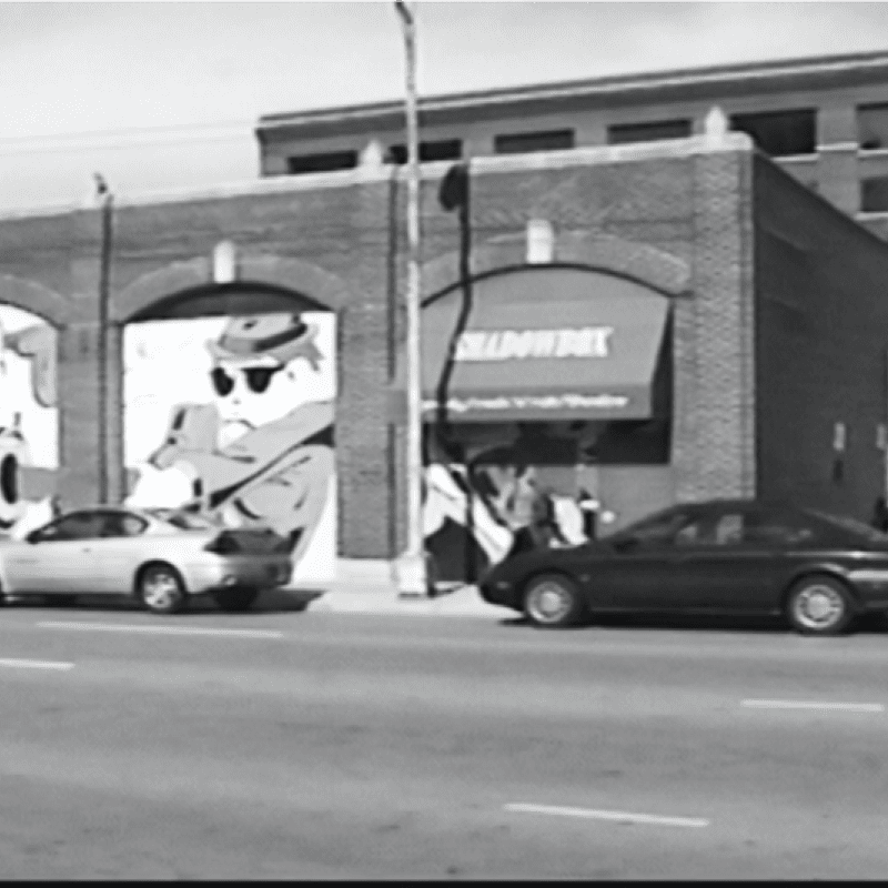 A black and white photo depicting the historic building adorned with vibrant graffiti artwork.