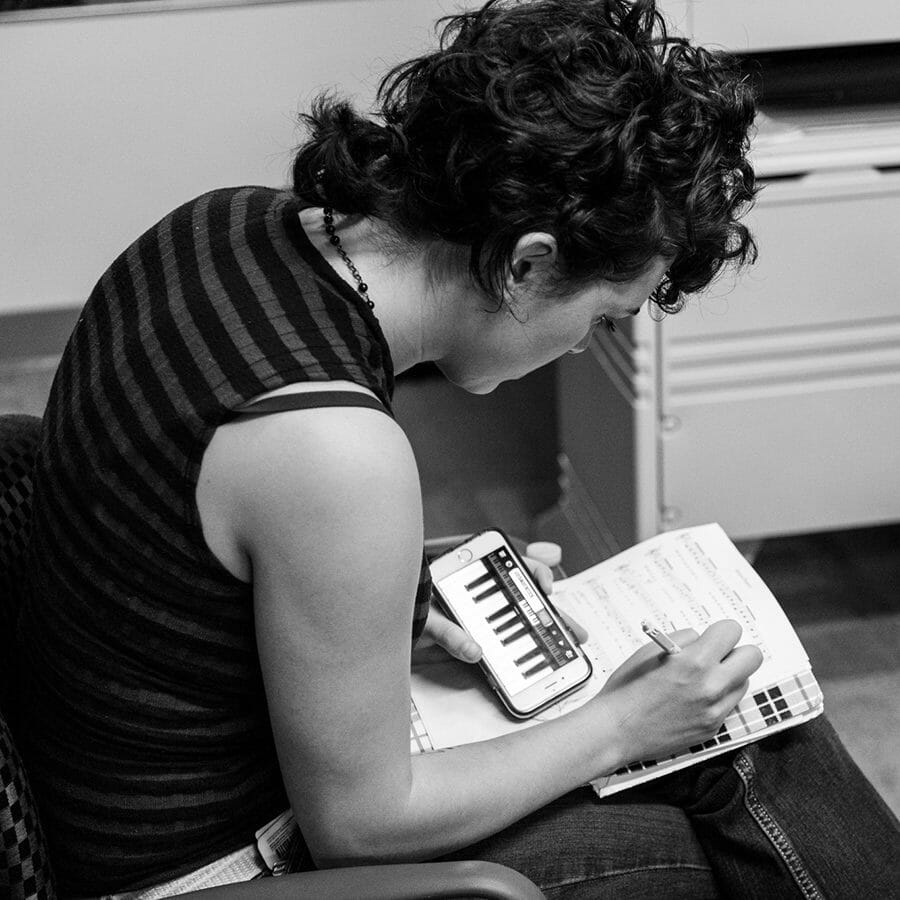 A woman writing in a notebook during auditions.