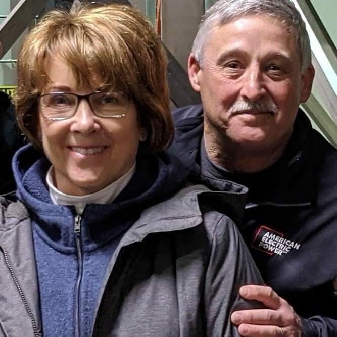 Karen & Rich Rosen, a couple featured in the donor spotlight, posing for a photo in front of an escalator.